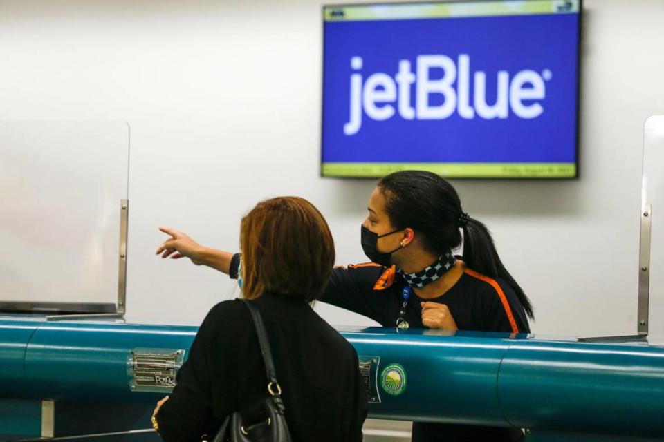 Un empleado en el mostrador de pasajes de JetBlue muestra el camino a un viajero en el Aeropuerto Internacional de Miami (MIA) en Miami, el 6 de agosto de 2021.