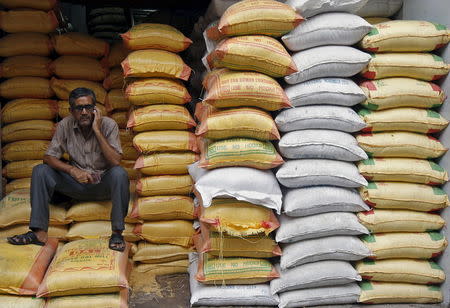 A worker speaks on a mobile phone as he sits inside a shop selling cereal, grains, and pet food, in Kolkata April 15, 2015. REUTERS/Rupak De Chowdhuri