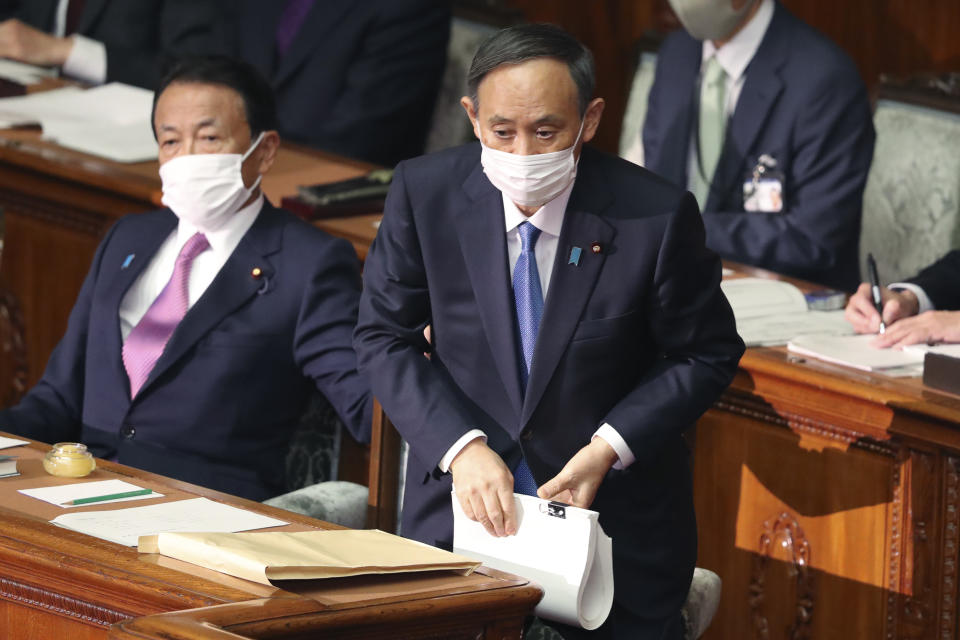 Japanese Prime Minister Yoshihide Suga, right, attends an ordinary Diet session at the upper house of parliament in Tokyo, Monday, Jan. 18, 2021. (AP Photo/Koji Sasahara)