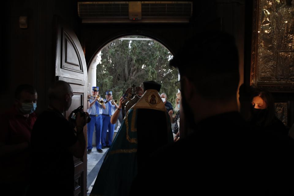 Metropolitan Dorotheos of Syros and Tinos holds an icon believed to perform miracles during a service in the Holy Church of Panagia, on the Aegean island of Tinos, Greece, on Thursday, Aug. 13, 2020. For nearly 200 years, Greek Orthodox faithful have flocked to Tinos for the August 15 feast day of the Assumption of the Virgin Mary, the most revered religious holiday in the Orthodox calendar after Easter. But this year there was no procession, the ceremony _ like so many lives across the globe _ upended by the coronavirus pandemic. (AP Photo/Thanassis Stavrakis)