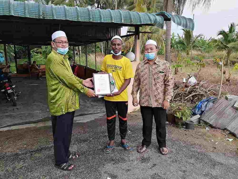 Perak Kafar teacher, Muhammad Nor Imran Maula Abd Jalil, receiving an appreciation certificate from the Bagan Datuk District Islamic Office. — Picture via Facebook/PerakPress