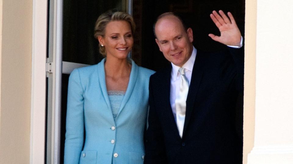 Princess Charlene and Prince Albert waving from balcony