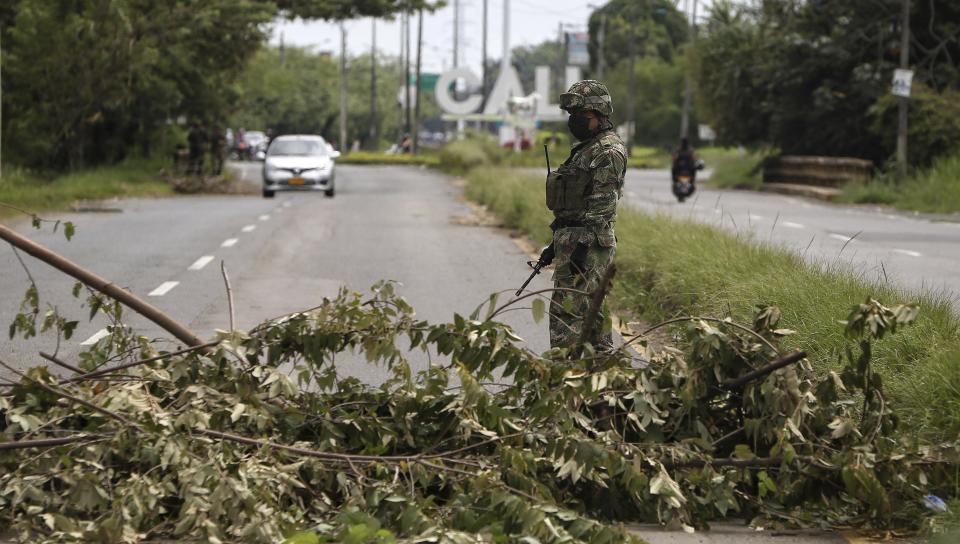 A soldier stands guard at a road block that was cleared after it was set up by anti-government protesters during a national strike in Cali, Colombia, Monday, May 10, 2021. Colombians have protested across the country against a government they feel has long ignored their needs, allowed corruption to run rampant and is so out of touch that it proposed tax increases during the coronavirus pandemic. (AP Photo/Andres Gonzalez)