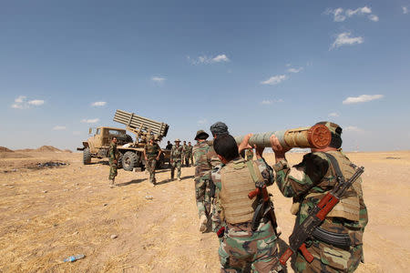 Iraqi Kurdish peshmerga troops load rockets into a launcher during fighting with Islamic State militants in Khazir, September 16, 2014. REUTERS/Azad Lashkari