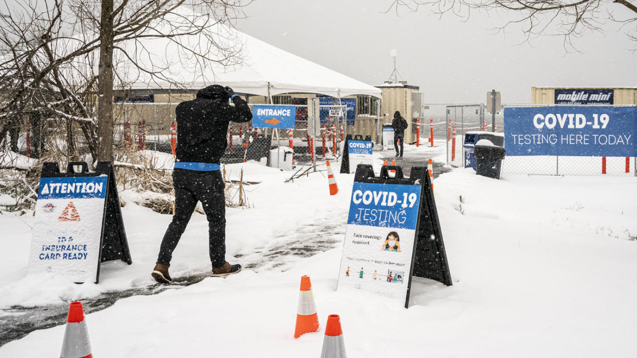 People enter a snow-covered COVID-19 testing site in February in Seattle. 