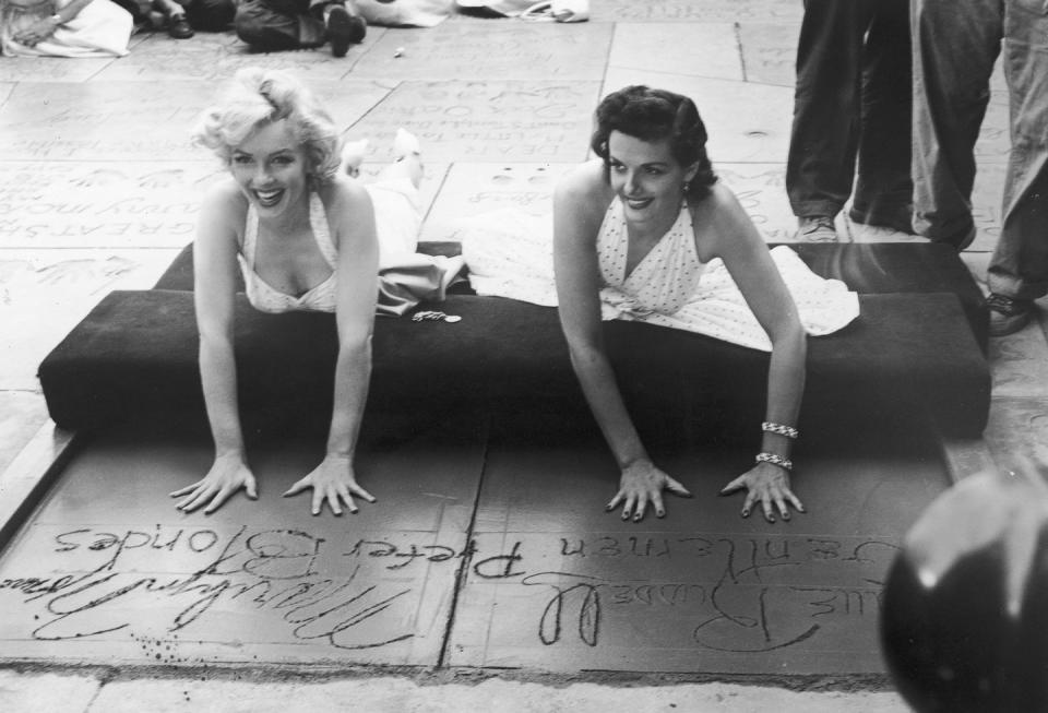 <p>Marilyn left her hand and footprints in the cement at Grauman's Chinese Theater in Los Angeles. She's accompanied by Jane Russell, her co-star in <em>Gentlemen Prefer Blondes</em>.</p>