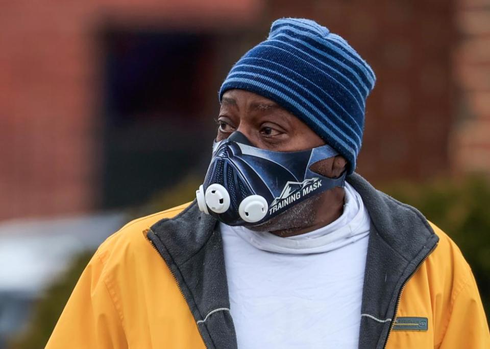 A man wears a protective face mask as he walks through the predominately black south side of Chicago.