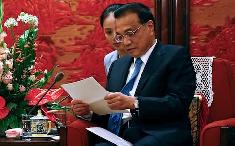 Chinese Premier Li Keqiang reads a letter from Malaysia's Prime Minister Mahathir Mohamad during his meeting with Malaysia's new government advisor Daim Zainuddin  - Credit: AP