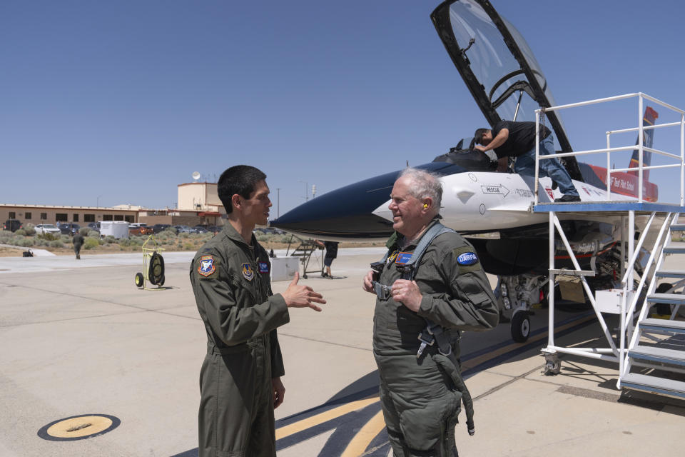 Air Force Secretary Frank Kendall, right, talks to Col. James Valpiani, Commandant, USAF TPS, after Kendall's test flight of the X-62A VISTA aircraft against a human-crewed F-16 aircraft in the skies above Edwards Air Force Base, Calif., on Thursday, May 2, 2024. The flight is serving as a public statement of confidence in the future role of AI in air combat. The military is planning to use the technology to operate an unmanned fleet of 1,000 aircraft. (AP Photo/Damian Dovarganes)