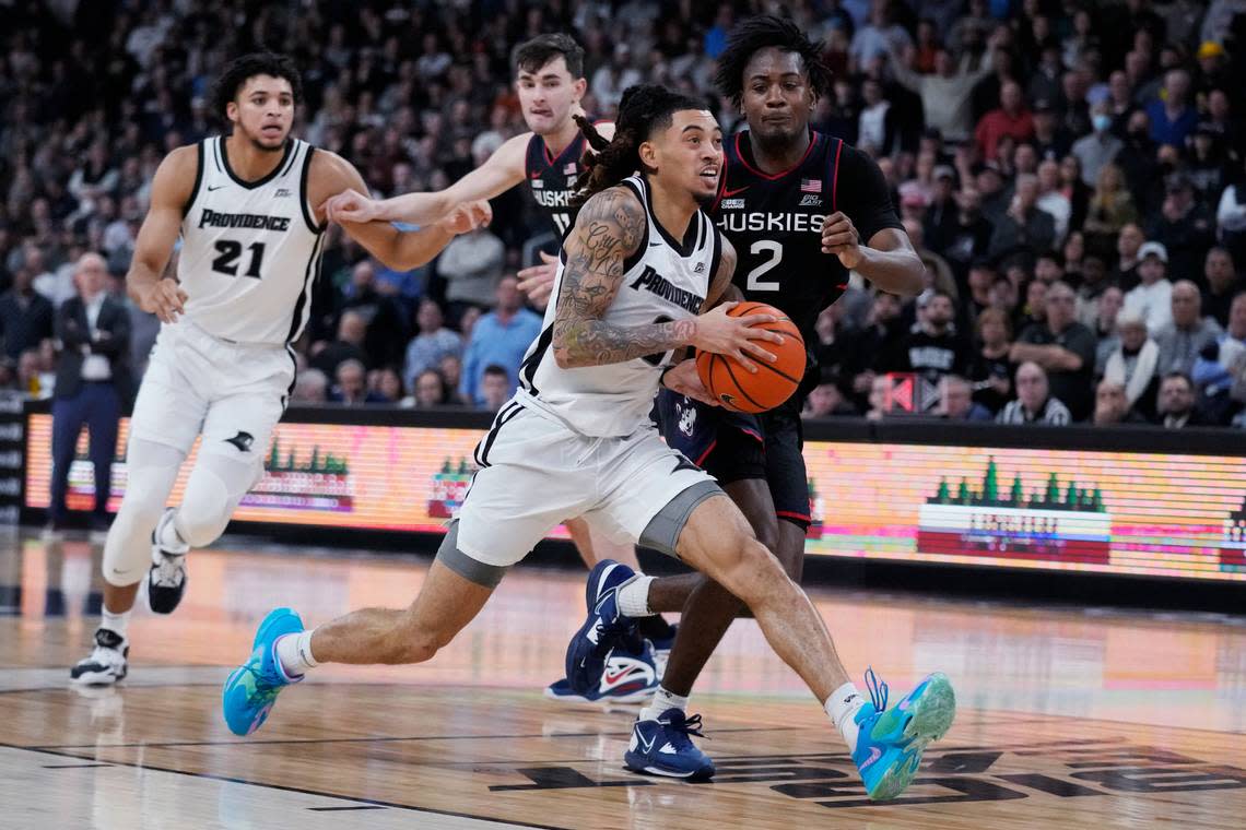 Providence guard Alyn Breed (0) drives to the basket past Connecticut guard Tristen Newton (2) during the second half of an NCAA college basketball game, Wednesday, Jan. 4, 2023, in Providence, R.I. Providence upset #4 Connecticut 73-61. (AP Photo/Charles Krupa)