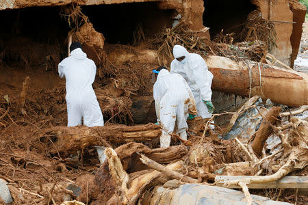 Rescue workers are seen searching through rubble and debris around a house for bodies at Pentagon, Regent town, Sierra Leone August 18, 2017. REUTERS/Afolabi Sotunde