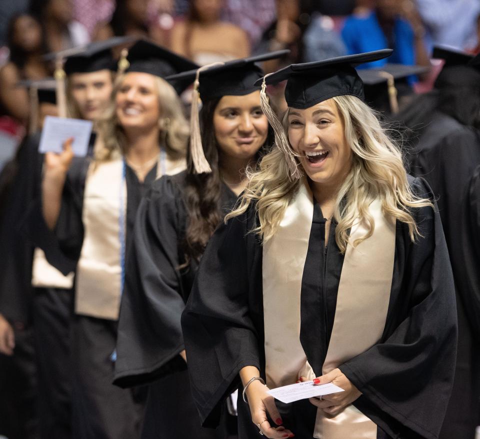 May 6, 2022; Tuscaloosa, AL, USA;  Members of the 2022 graduating class look for and wave to family and friends as they enter Coleman Coliseum for Spring Commencement at the University of Alabama Friday. Graduation exercises continue through Sunday. The university expects more than 5,000 graduates to participate in one of eight graduation ceremonies. Mandatory Credit: Gary Cosby Jr.-The Tuscaloosa News