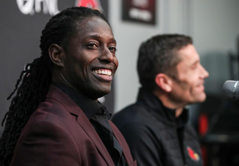 Louisville interim head football coach Deion Branch smiles Monday afternoon, as Louisville AD Josh Heird talks in the background. Dec. 5, 2022