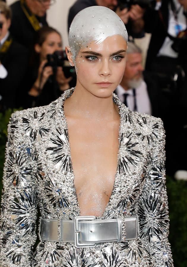 Cara Delevingne painted her shaved head silver for the Met Gala. Photo: Getty