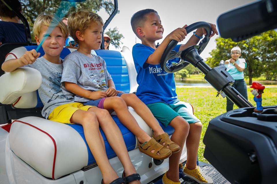 Charlie Maloney, right, at driver's wheel, looks over his new Mario Bros. themed golf cart with friends and family during a Make-A-Wish event at Caloosa Park on July 21.
(Credit: THOMAS CORDY/THE PALM BEACH POST)