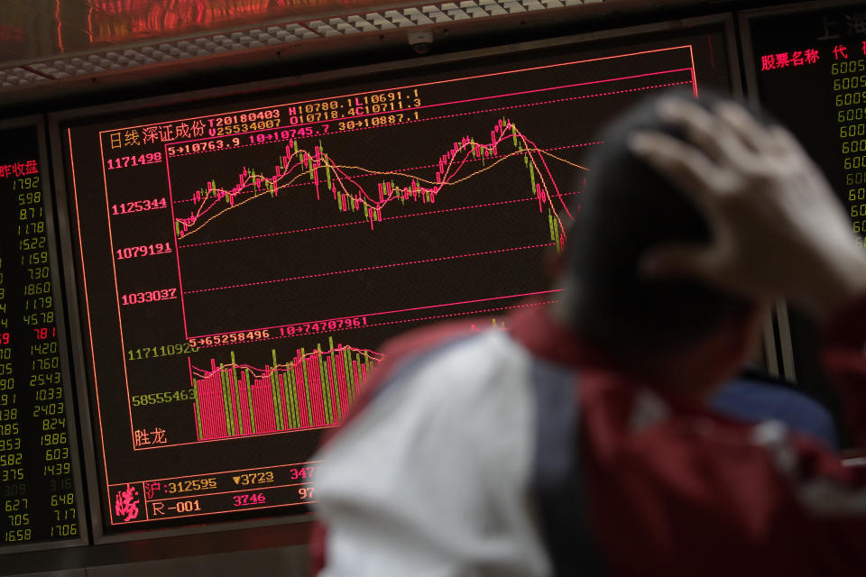 A man looks at an electronic board displaying stock trading index at a brokerage house. (AP Photo/Andy Wong)