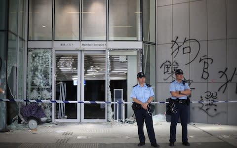 Police officers stand guard at the Legislative Council Building after protesters stormed the building in Hong Kong - Credit: Rex