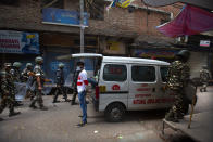 Indian paramilitary force soldiers patrol as an ambulance stationed at the area which witnessed Tuesday's violence in New Delhi, India, Wednesday, Feb. 26, 2020. At least 20 people were killed in three days of clashes in New Delhi, with the death toll expected to rise as hospitals were overflowed with dozens of injured people, authorities said Wednesday. The clashes between Hindu mobs and Muslims protesting a contentious new citizenship law that fast-tracks naturalization for foreign-born religious minorities of all major faiths in South Asia except Islam escalated Tuesday. (AP Photo/Rajesh Kumar Singh)