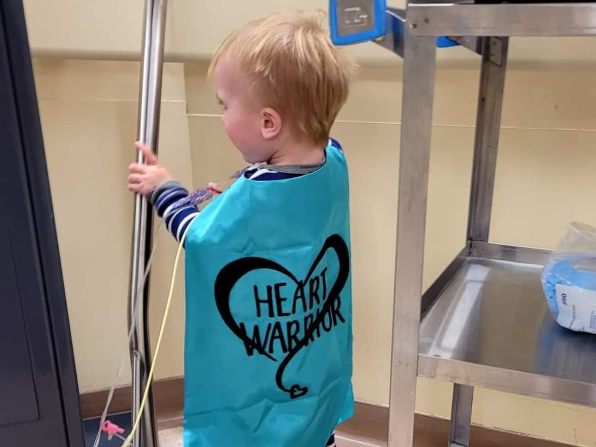 John Dawson, now, 2, with his 'Heart Warrior' gown on in a Toronto hospital. John returned home to P.E.I. this week with a new heart.  (Submitted by Kali Dawson - image credit)