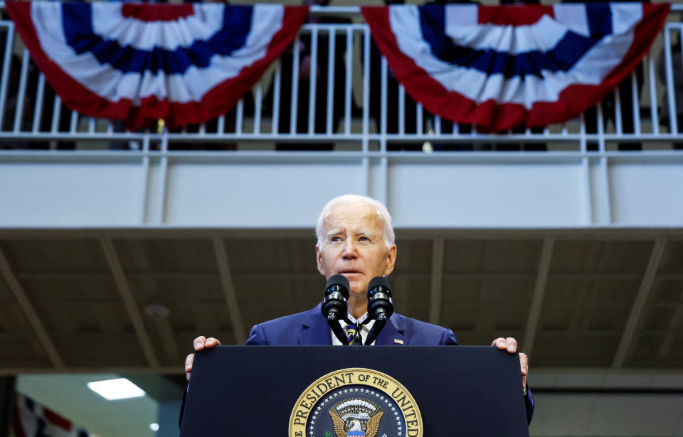 President Biden stands at a podium outdoors.