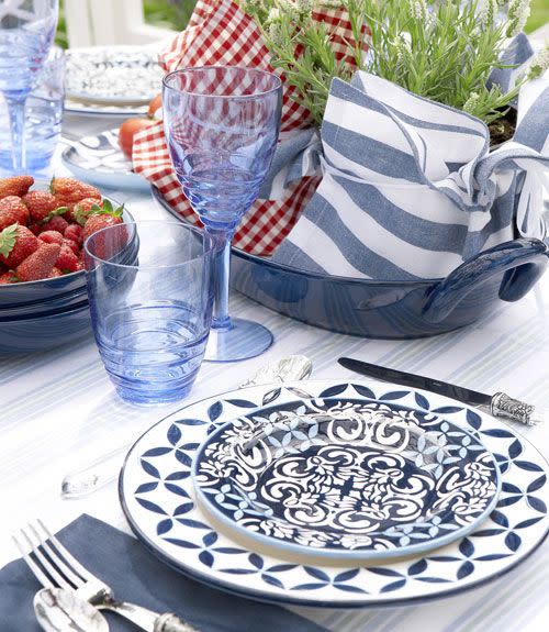 <p>No need to shop for a special table topper. Raid your cabinets for color-coordinated items instead. Here, crisp cotton napkins — cinched around a pair of potted plants with kitchen twine — and a tray transform into a fast, festive centerpiece. </p>