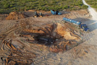 In this June 2021 photo provided by rancher Ashley Williams Watt, the Estes 24 well leaks on the Antina ranch near Crane, Texas. Chevron, which is responsible for the abandoned well, has been working to re-plug it. Buried under the sand, it became unplugged and started leaking produced water, a byproduct of oil production that is considered a toxic substance. The rancher's biggest worry is that it will get into her drinking water supply and the watershed, which flows into the nearby Pecos River. (Ashley Williams Watt via AP)
