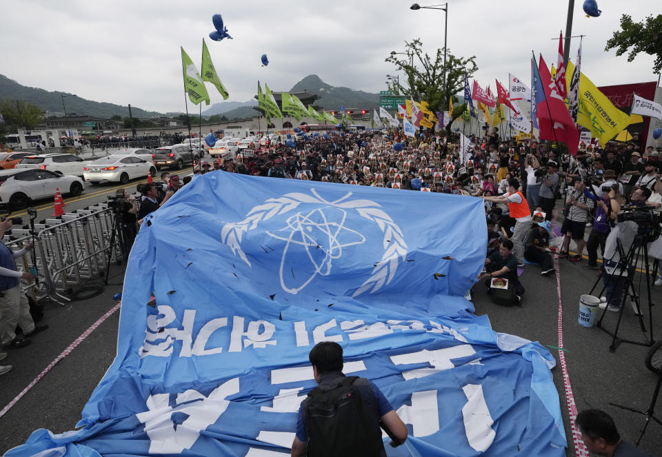 Protesters pull a flag symbolizing IAEA (International Atomic Energy Agency) in an attempt to tear it apart during a rally against the Japanese government's decision to release treated radioactive water from the damaged Fukushima nuclear power plant, in Seoul, South Korea, Saturday, July 8, 2023. (AP Photo/Ahn Young-joon)