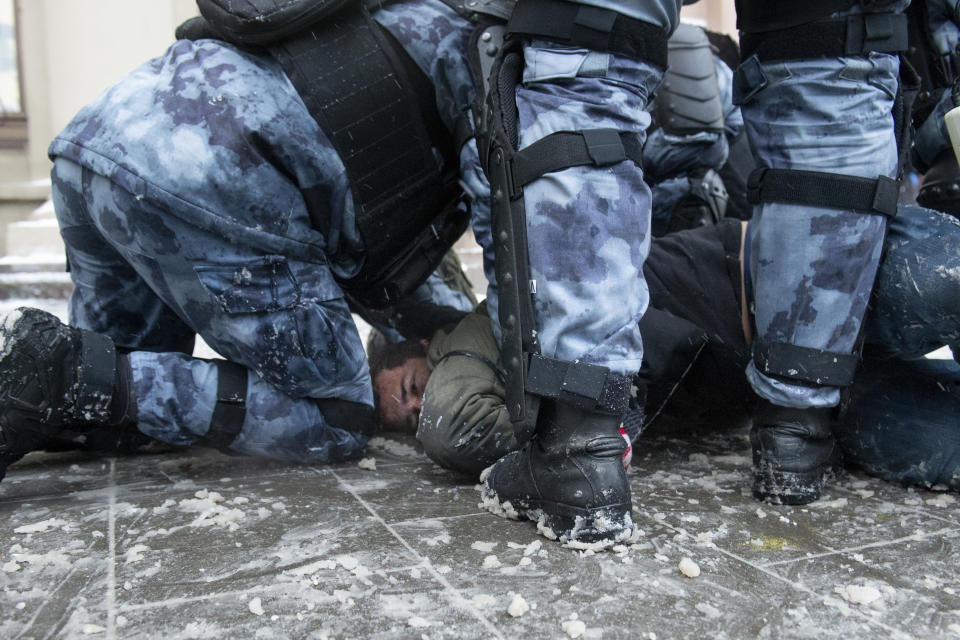 Police officers detain a man during a protest against the jailing of opposition leader Alexei Navalny in Moscow, Russia, on Sunday, Jan. 31, 2021. Tens of thousands of people are protesting across Russia to demand the release of jailed opposition leader Alexei Navalny in wave of nationwide demonstrations that have rattled the Kremlin. Many chanted slogans against President Vladimir Putin. Activists say police detained more than 3,300 protesters across the country on Sunday, including over 900 in Moscow. (AP Photo/Denis Kaminev)