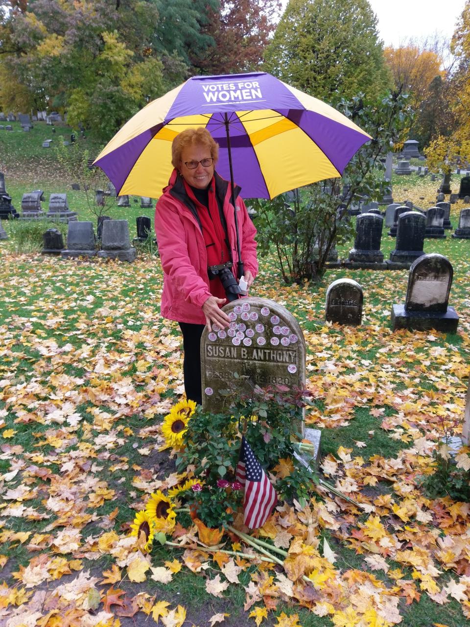 In this photo provided by the National Susan B. Anthony Museum & House, Emily Jones poses at the grave of Susan B. Anthony in Rochester, N.Y., Tuesday, Nov. 6, 2018. Voters showed up by the dozens to put their “I Voted” stickers on the headstone, an Election Day ritual that pays homage to the voting rights pioneer. (Deborah L. Hughes/National Susan B. Anthony Museum & House via AP)