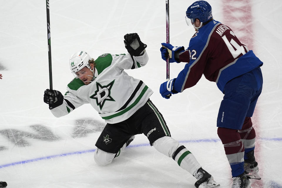 Colorado Avalanche defenseman Josh Manson, right, knocks over Dallas Stars center Roope Hintz, left, in the first period of Game 3 of an NHL hockey Stanley Cup playoff series Saturday, May 11, 2024, in Denver. (AP Photo/David Zalubowski)