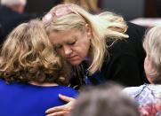Burnette Chapel Church of Christ member Brenda Enderson hugs a family member of Melanie Crow, a victim in a 2017 church shooting, before the verdict is announced in the trial of Emanuel Samson on Friday, May 24, 2019. Samson was found guilty of first-degree murder in the 2017 shooting at a Nashville church that left a woman dead and seven wounded. Jurors deliberated less than five hours before finding Samson guilty on all 43 counts in the indictment. (Shelley Mays/The Tennessean via AP, Pool)