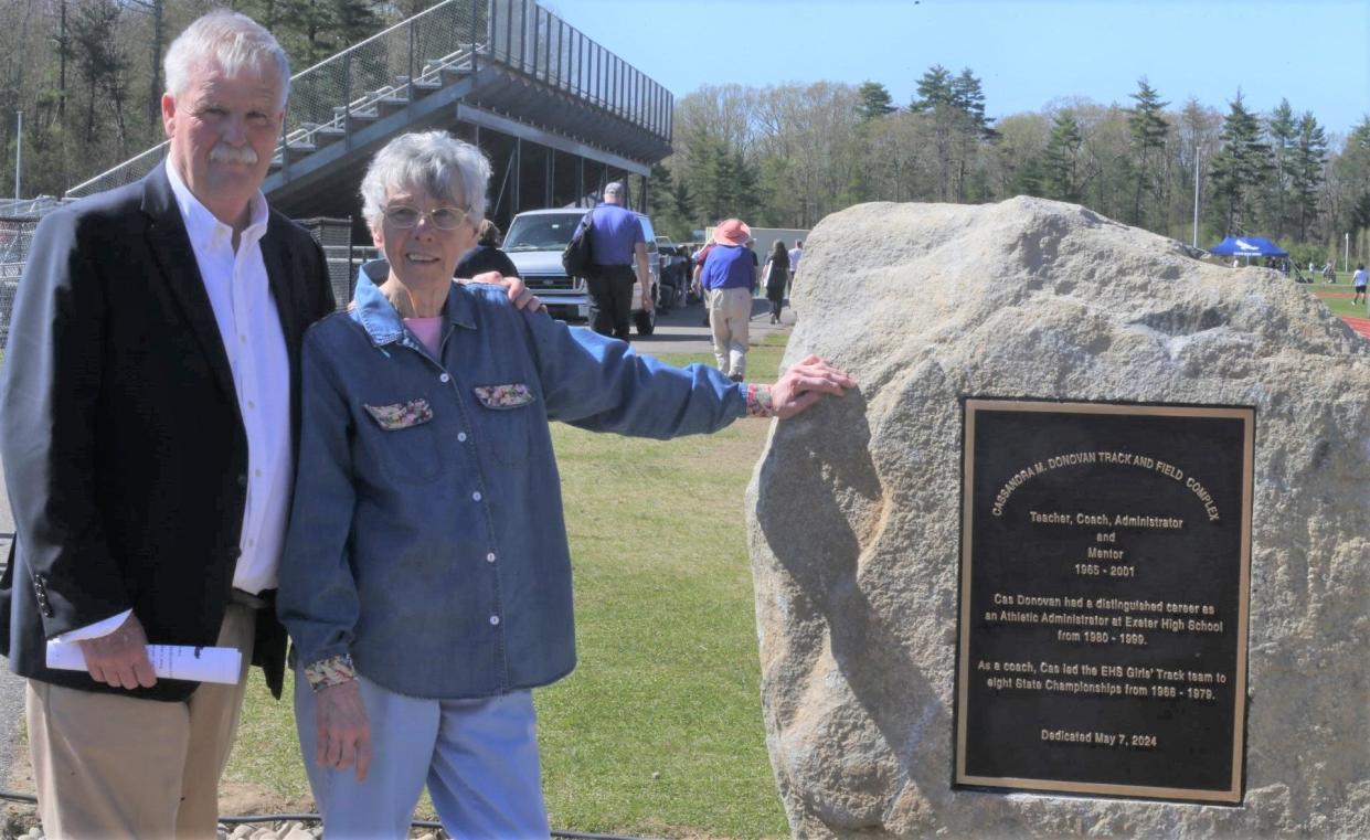 Exeter High School athletic director Bill Ball, left, stands with former longtime Exeter coach and athletic director Cassandra Donovan at the unveiling of Donovan's plaque at the high school track field on Tuesday. Donovan was the first girls track coach at Exeter High School in 1966.