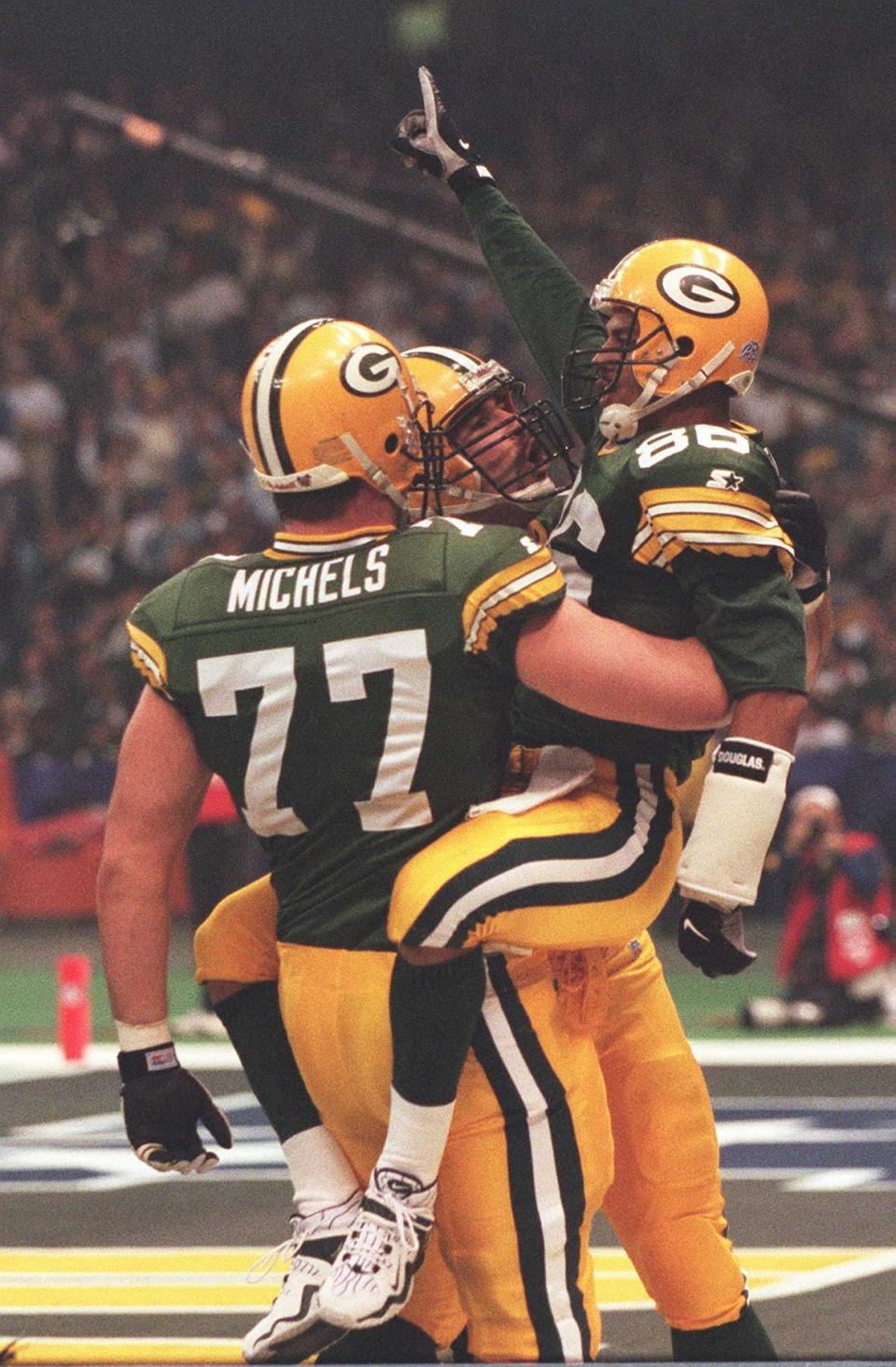 Text: Green Bay Packers Antonio Freeman is embraced by tackle John Michels (77) and Mark Chmura after scoring a second quarter tochdown against the New England Patriots during the Super Bowl, January 26, 1997 at the Superdome in New Orleans, La.(Milwaukee Journal Sentinel photo by Jeffrey Phelps)