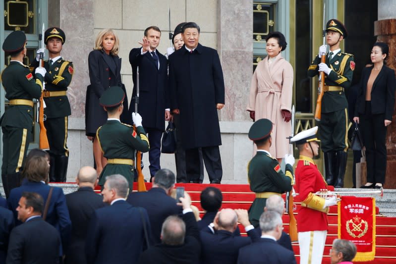 French President Emmanuel Macron and his wife Brigitte Macron attend a welcome ceremony with Chinese President Xi Jinping and his wife Peng Liyuan outside the Great Hall of the People in Beijing