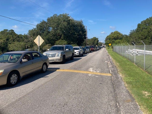 Cars line up along the street leading to the Mulberry sandbag distribution site on Monday morning. Weather forecasters say Polk most of County could get three to eight inches of rain as Hurricane Ian passes Wednesday and Thursday.