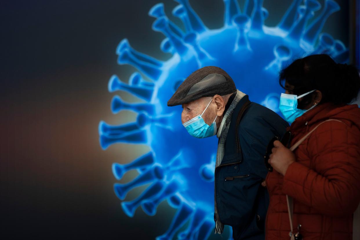 People wearing face masks wait to receive a coronavirus vaccine at a COVID-19 vaccination center in Jerusalem on Monday, Jan. 4, 2021.