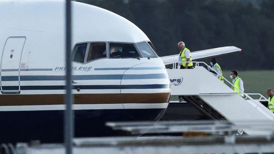 Members of the staff board a plane reported by British media to be first to transport migrants to Rwanda, at MOD Boscombe Down in June 2022