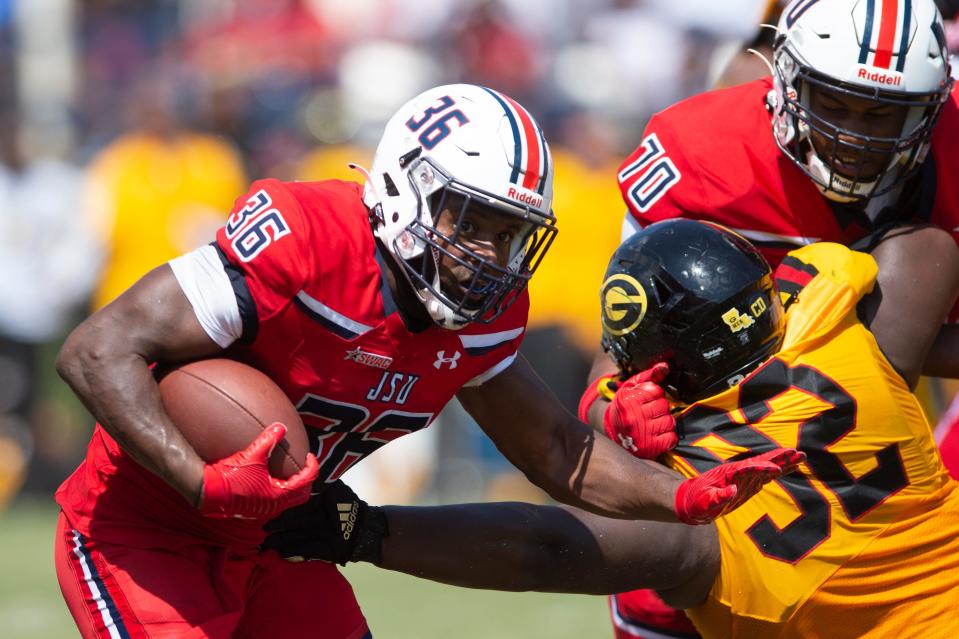 Jackson State running back Sy’veon Wilkerson (26) pushes forward as offensive lineman Kirk Ford (70) holds back Grambling defensive lineman Wesley Green (92) during an NCAA college football game in Jackson, Miss., Saturday, Sept. 17, 2022. JSU won 66-24.