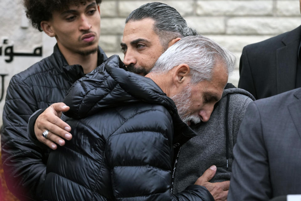 Wadea Al Fayoume's father, Oday Al Fayoume, right, hugs his uncle Mahmoud Yousef, front, during a news conference for Muslim community members at Mosque Foundation in Bridgeview, Ill., Monday, Oct. 16, 2023. An Illinois landlord accused of fatally stabbing the 6-year-old Muslim boy and seriously wounding his mother was charged with a hate crime after police and relatives said he singled out the victims because of their faith and as a response to the war between Israel and Hamas. (AP Photo/Nam Y. Huh)