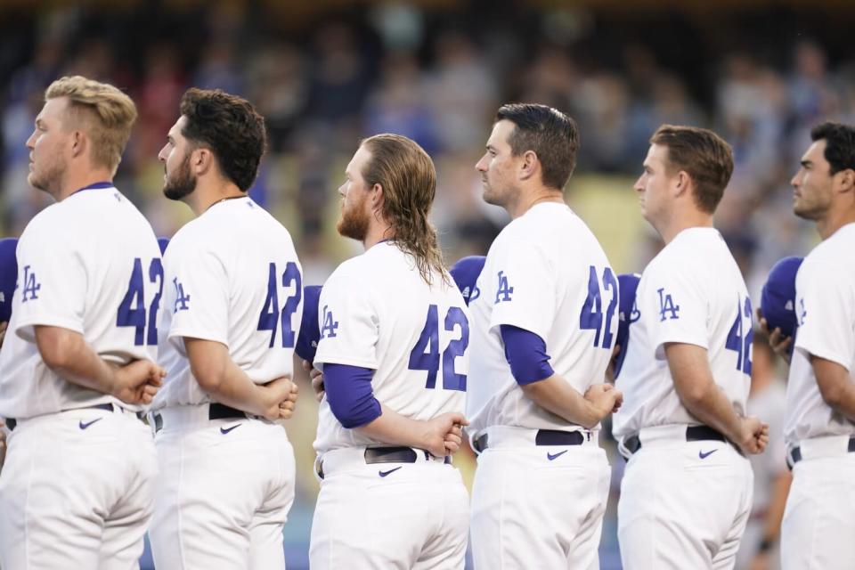 Los jugadores de los Dodgers visten el número 42, en honor a Jackie Robinson, mientras escuchan el himno nacional.