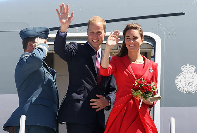 Prince William and Kate Middleton waving from outside their plane.