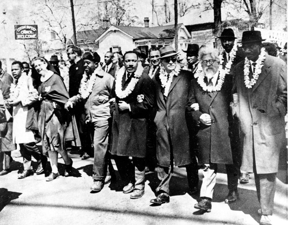 Dr. Martin Luther King Jr. links arms with other civil rights leaders as they begin the march to the state capitol in Montgomery from Selma, Ala. on March 21, 1965. The demonstrators are marching for voter registration rights for blacks. Accompanying Dr. Martin Luther King Jr. (fourth from right), are on his left Ralph Bunche, undersecretary of the United Nations, Rabbi Abraham Joshua Heschel, and Rev. Fred Shuttlesworth. They are wearing leis given by a Hawaiian group.