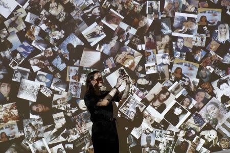 A gallery assistant poses for a photograph during a press day to promote the upcoming exhibition 'From Selfie to Self-Expression' at the Saatchi Gallery in London, Britain March 30, 2017. REUTERS/Stefan Wermuth