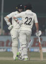 New Zealand's captain Kane Williamson, right, and Tom Latham talk during the day three of their first test cricket match with India in Kanpur, India, Saturday, Nov. 27, 2021. (AP Photo/Altaf Qadri)