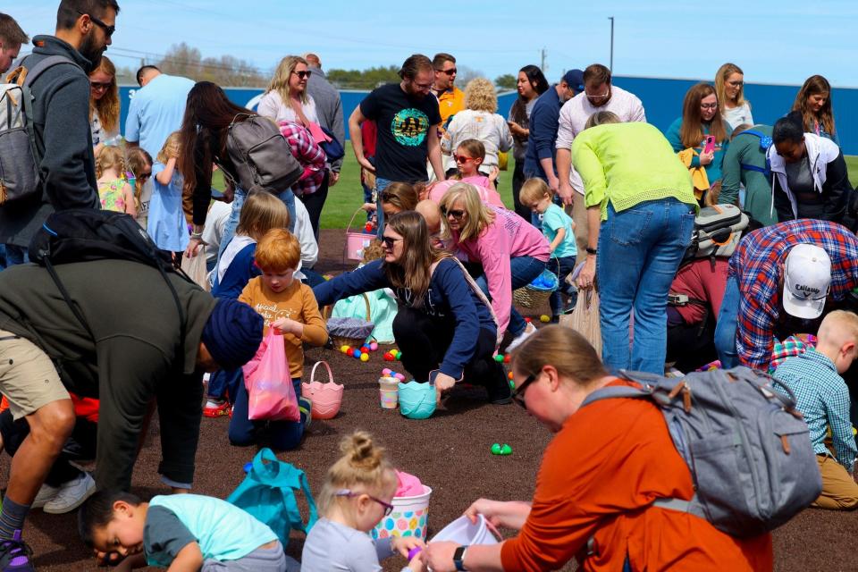 Parents help the bigger kids find special eggs leading to prizes at the annual Eggstravaganza at Grace Baptist Church.