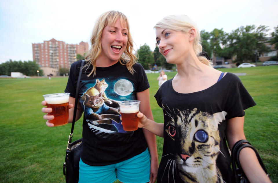 Lori Priefer, left, and Jessa Alt, both of Minneapolis, talk about their cat themed shirts after arriving at the Walker Art Center for the first "Internet Cat Video Film Festival," showcasing the best of cat films on the Internet in Minneapolis Thursday Aug. 30, 2012. The Walker Art Center in Minneapolis held its first-ever online cat video festival, a compilation of silly cat clips that have become an Internet phenomenon, attracting millions of viewers for some of the videos. (AP Photo/Craig Lassig)