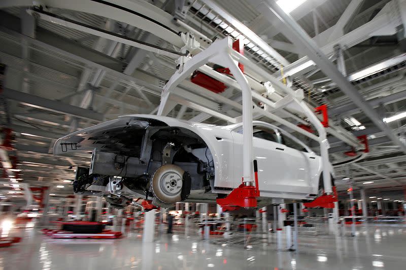 FILE PHOTO: The body of a Tesla Model S is transported by an automated crane at the Tesla factory in Fremont
