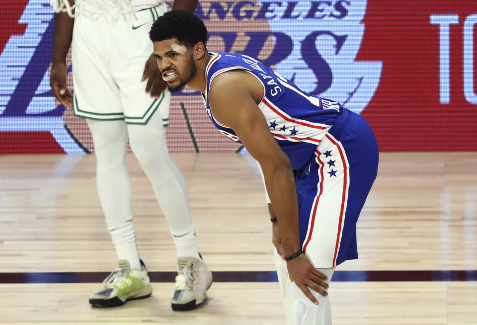Philadelphia 76ers forward Tobias Harris (12) reenters play after injuring himself during the fourth quarter of Game 4 of an NBA basketball first-round playoff series against the Boston Celtics, Sunday, Aug. 23, 2020, in Lake Buena Vista, Fla. (Kim Klement/Pool Photo via AP)