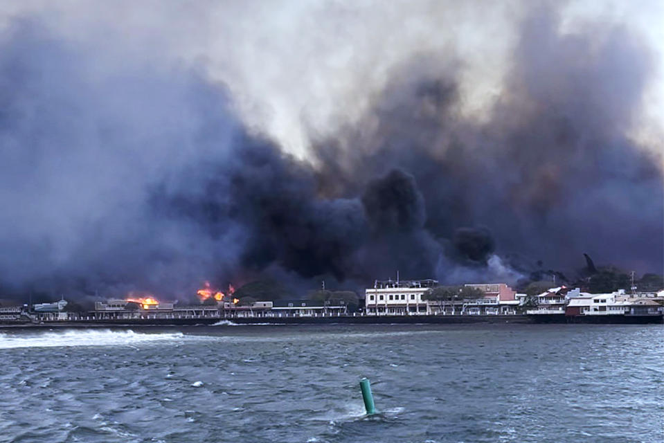 In this photo provided by Brantin Stevens smoke fill the air from wild fires at Lahaina harbor on Tuesday, Aug. 8, 2023 in Hawaii. Fire was widespread in Lahaina Town, including on Front Street, a popular shopping and dining area, County of Maui spokesperson Mahina Martin said by phone early Wednesday. Traffic has been very heavy as people try to evacuate the area, and officials asked people who weren’t in an evacuation area to shelter in place to avoid adding to the traffic, she said. (Brantin Stevens via AP)