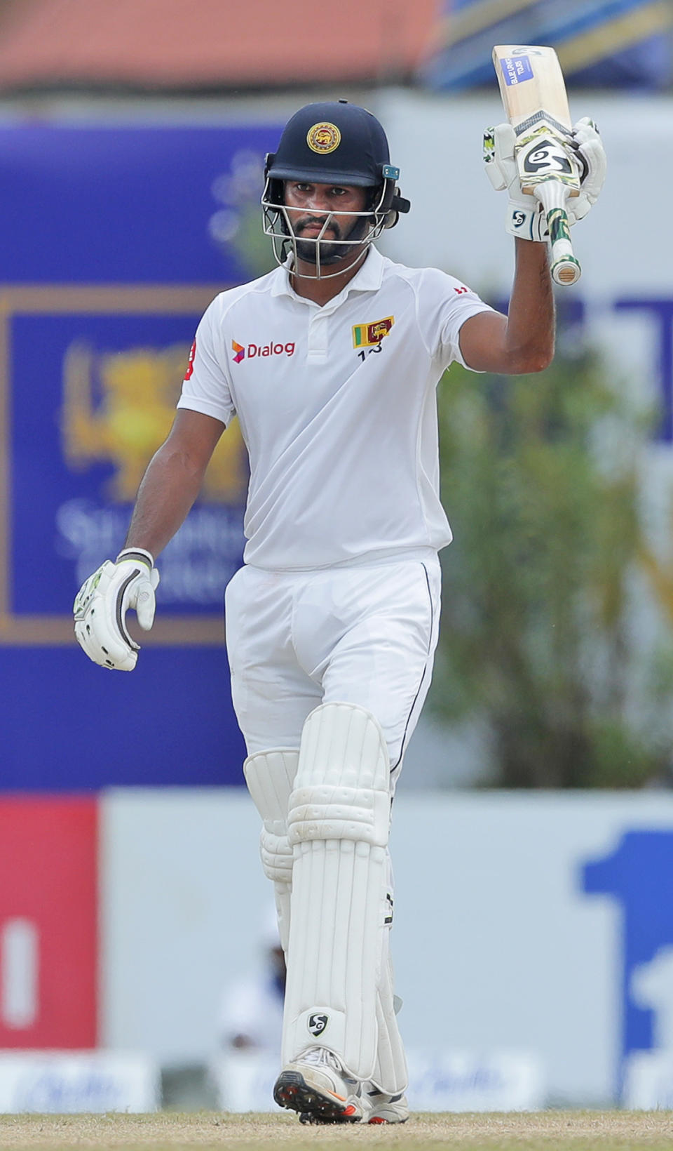 Sri Lanka's Dimuth Karunaratne celebrates scoring a half century during the fourth day of the first test cricket match between Sri Lanka and New Zealand in Galle, Sri Lanka, Saturday, Aug. 17, 2019. (AP Photo/Eranga Jayawardena)